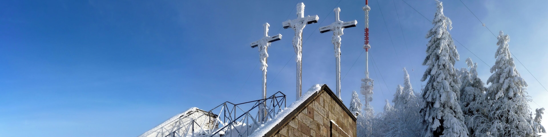 Der Kreuzberg, mit 928 Meter über Normalnull der höchste Berg im bayerischen Teil der Rhön, bei minus zehn Grad Celsius Lufttemperatur und etwa zwanzig Zentimeter Schnee. Im Hintergrund der Sender Kreuzberg, ein 1985 erbauter, 208 Meter hoher Stahlrohrmast. Vorne die zwölfte Station des im Jahr 1710 entstandenen Kapellenkreuzweges, dem vermutlich ältesten Kapellenkreuzweg in Deutschland. Links davon die Stationen neun bis elf.