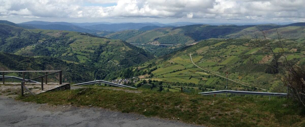 A mountainous landscape with winding roads and a bridge.