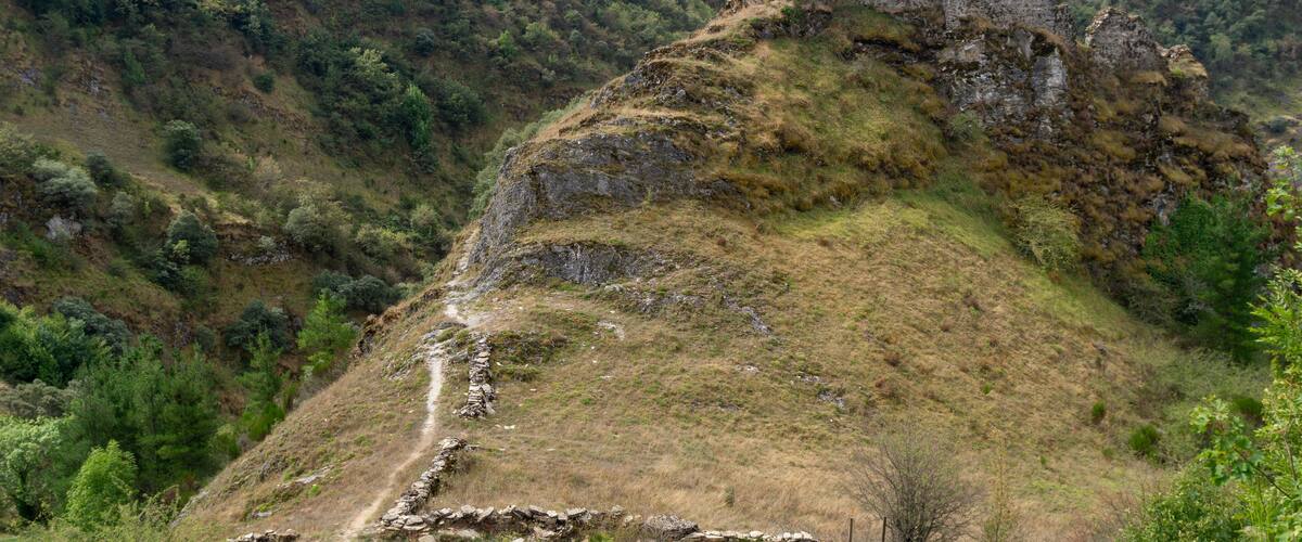 A hill with ruins and a path.