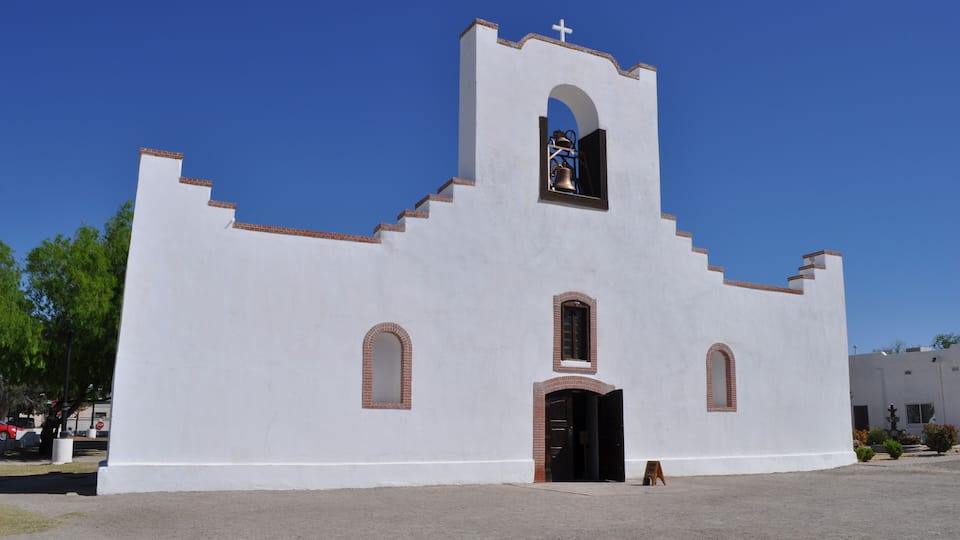 A white church with a bell tower and arched windows.