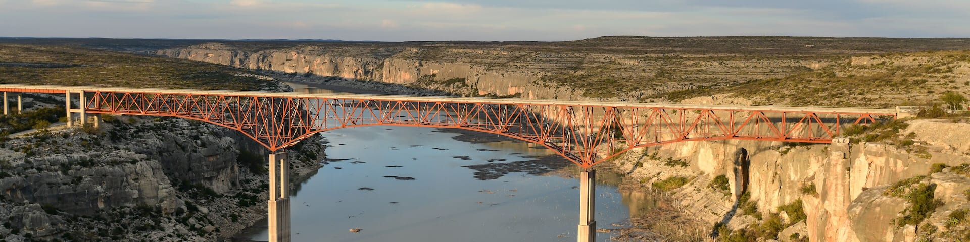 A bridge spanning a river over a canyon.