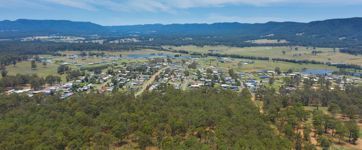 An aerial view of a town surrounded by dense forests and hills.