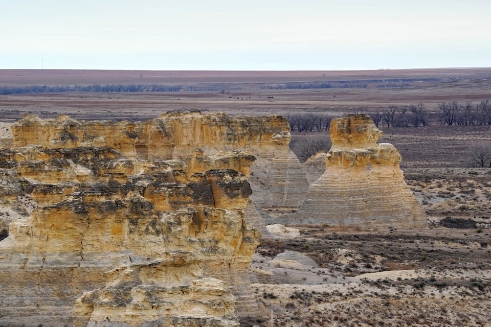A landscape with prominent rock formations and a flat horizon.