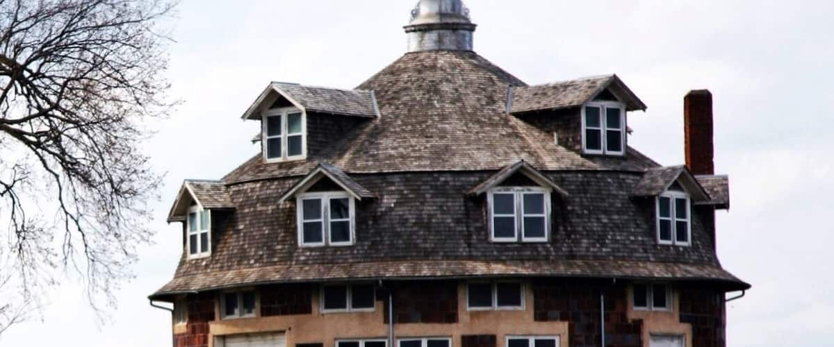 A large, two-story house with a steeply pitched roof and a prominent chimney.