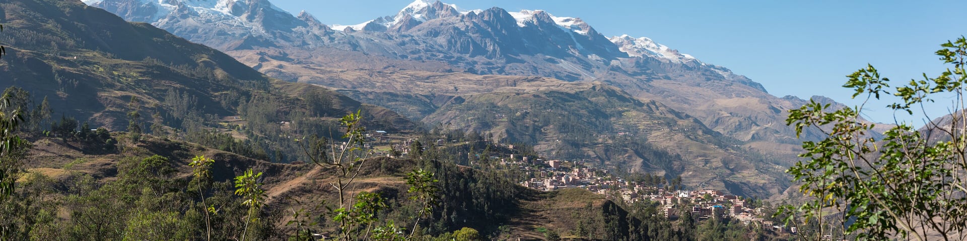panoramic view of sorata town, mountain Ancohuma and mountain illampu, the third and fourth highest mountains in Bolivia in the andes moutain range with a blue sky illuminated with natural light