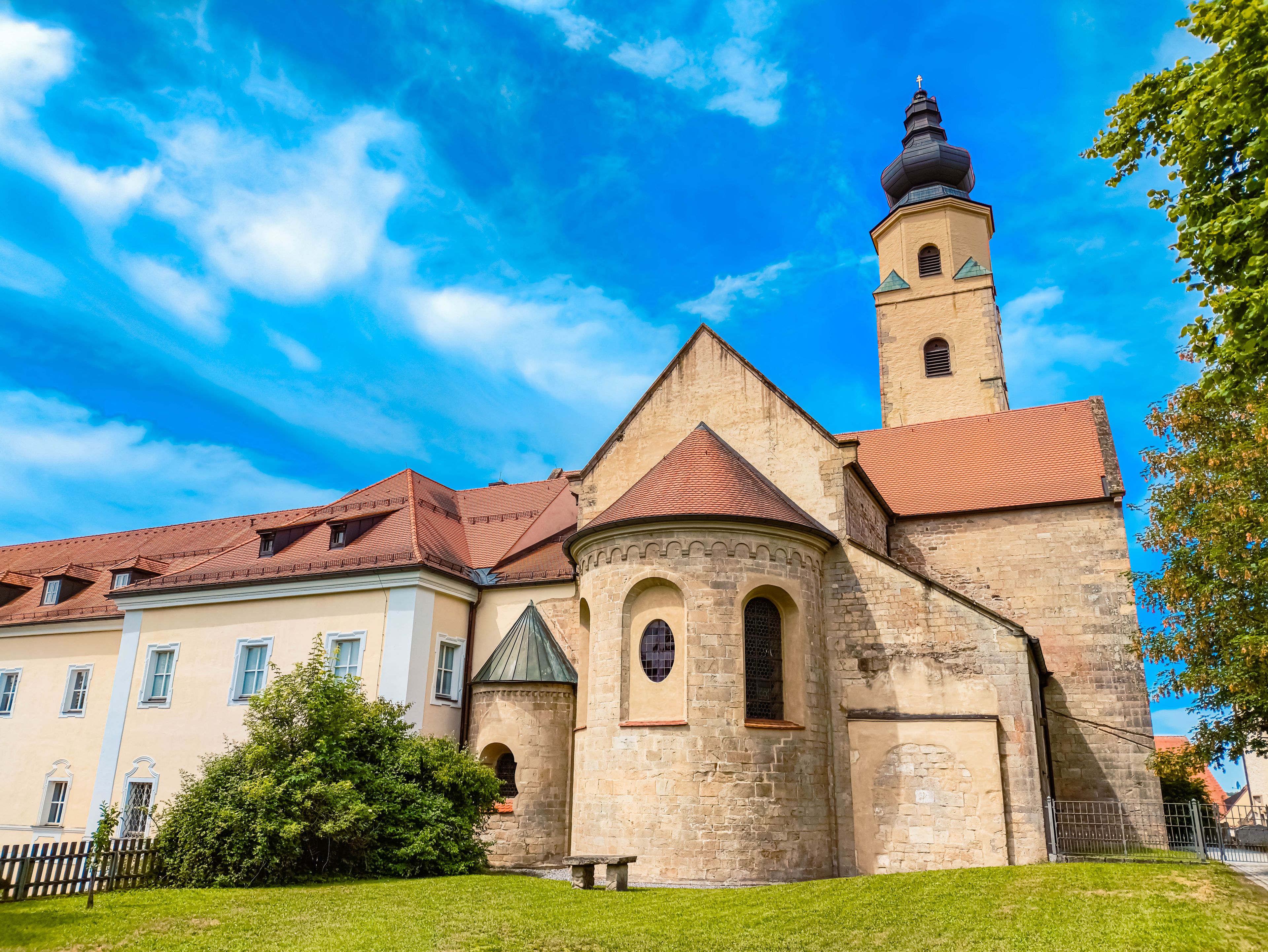 A historic church with a prominent bell tower and a red-tiled roof.