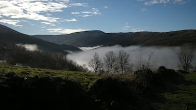 A valley with mist-covered hills and a clear blue sky.
