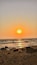 A sunset over a rocky beach with waves.