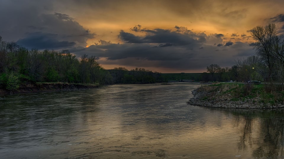 A river with a cloudy sky reflecting on the water.