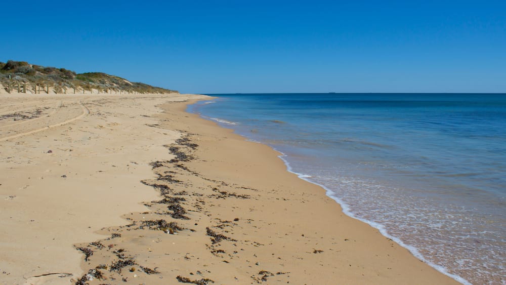 Beautiful scenic views of access to pristine Binningup Beach Western Australia on a sunny afternoon in late summer highlights the peaceful Indian Ocean lapping on the sandy shore., Shutterstock I