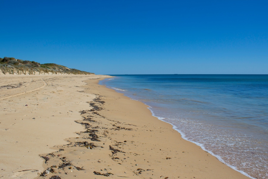 Beautiful scenic views of access to pristine Binningup Beach Western Australia on a sunny afternoon in late summer highlights the peaceful Indian Ocean lapping on the sandy shore., Shutterstock I