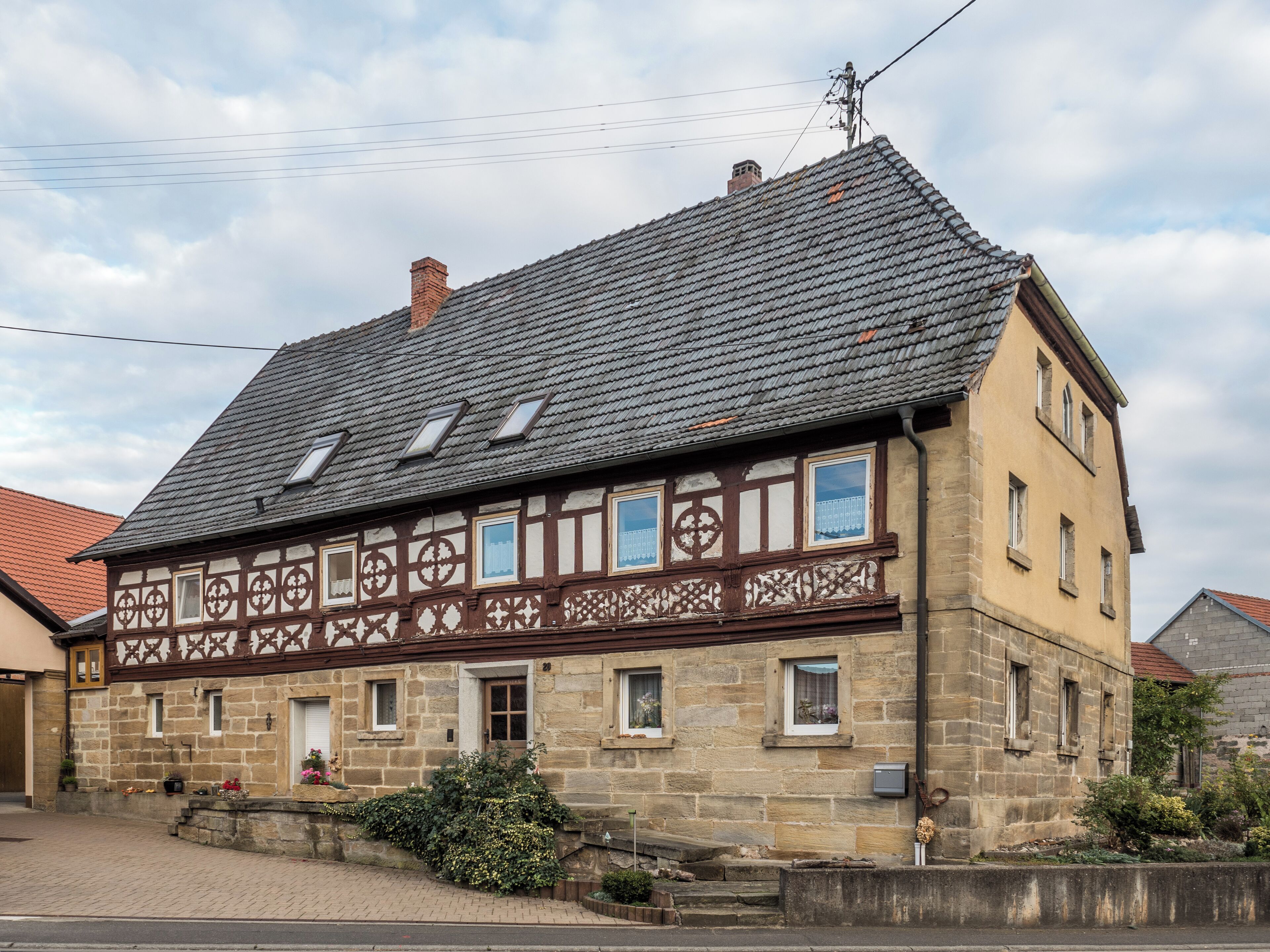 A traditional half-timbered house with a steeply pitched roof and dormer windows.