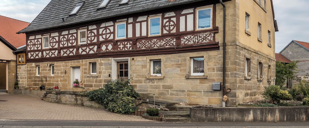 A traditional half-timbered house with a steeply pitched roof and dormer windows.