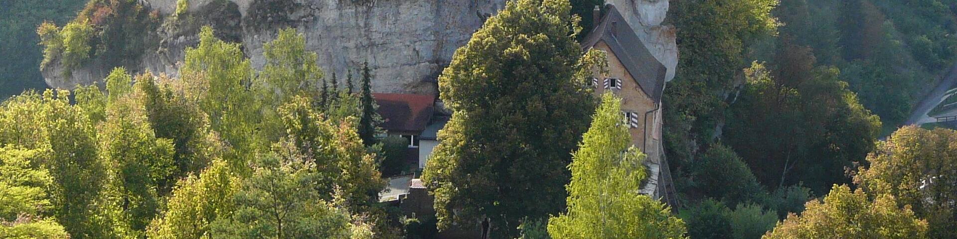 A castle perched on a cliff surrounded by lush greenery.