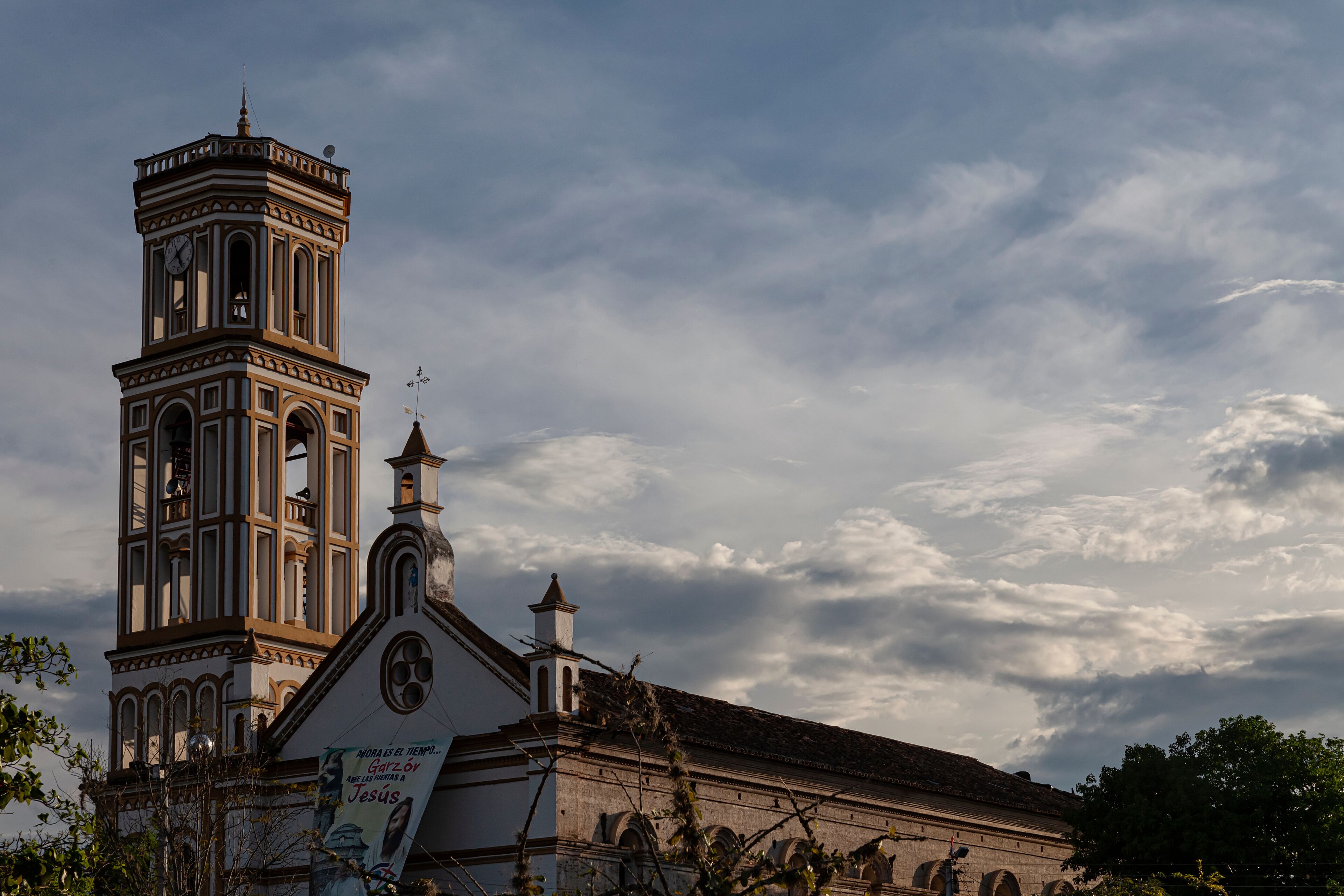 A church with a clock tower and a bell.