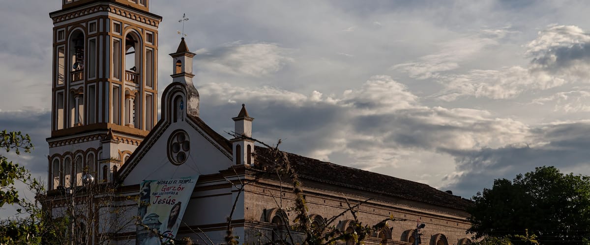 A church with a clock tower and a bell.