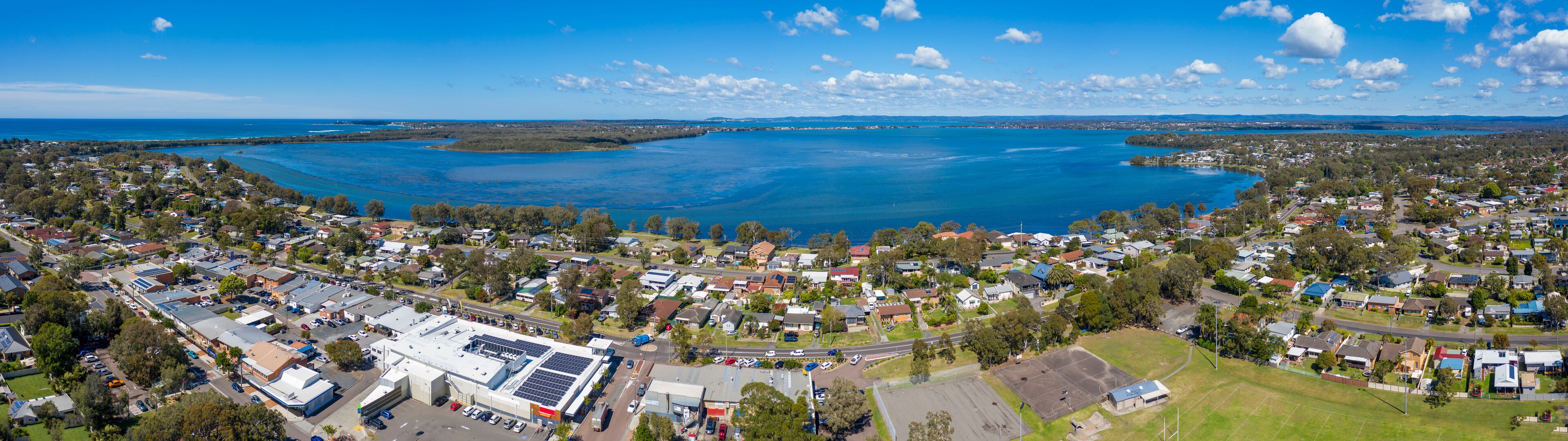 A coastal town with a large body of water, residential areas, and a solar power plant.