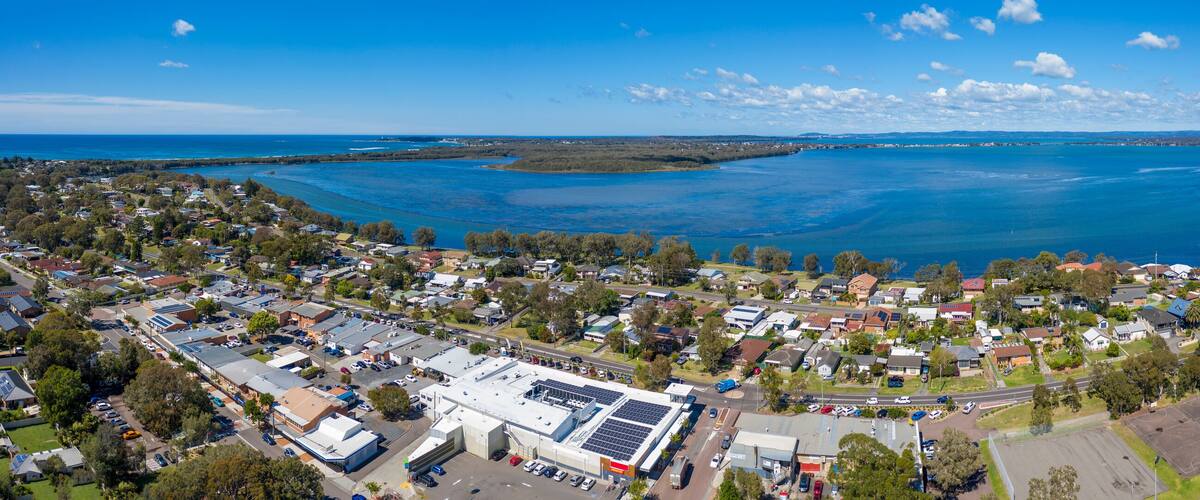 A coastal town with a large body of water, residential areas, and a solar power plant.