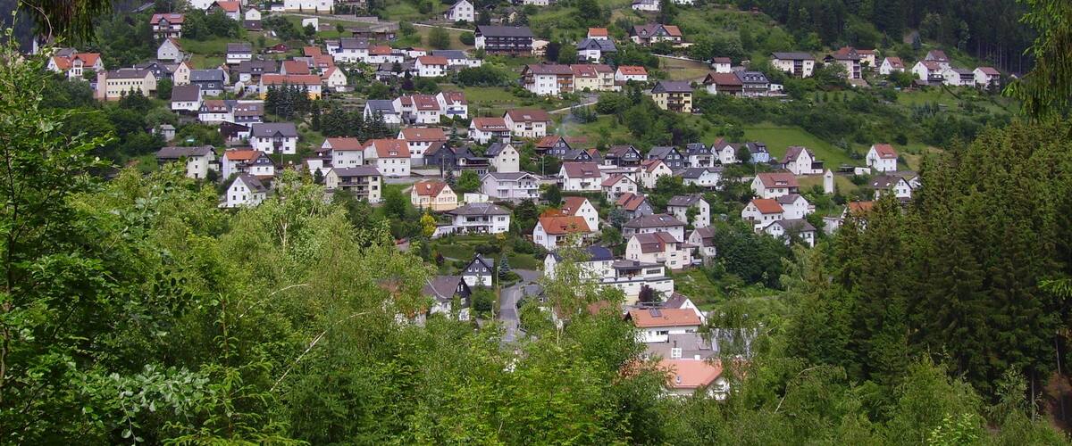 A hillside village with houses and a church on top.