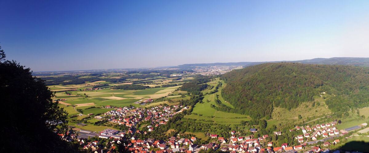 A town nestled in a valley surrounded by forested hills.