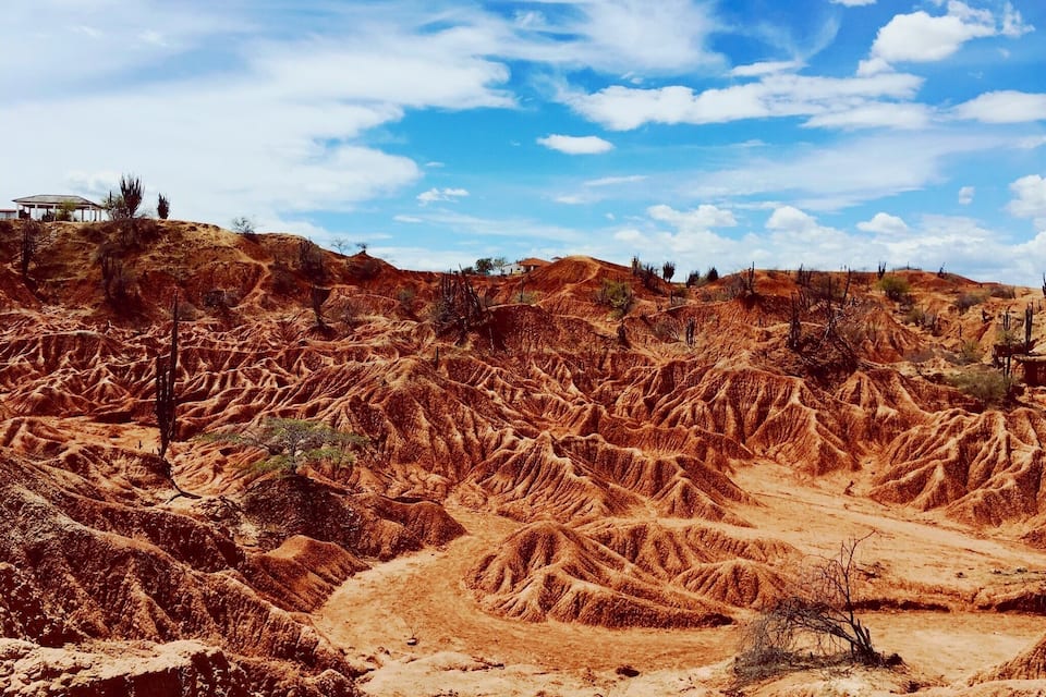 A rugged, arid landscape with undulating hills and sparse vegetation.