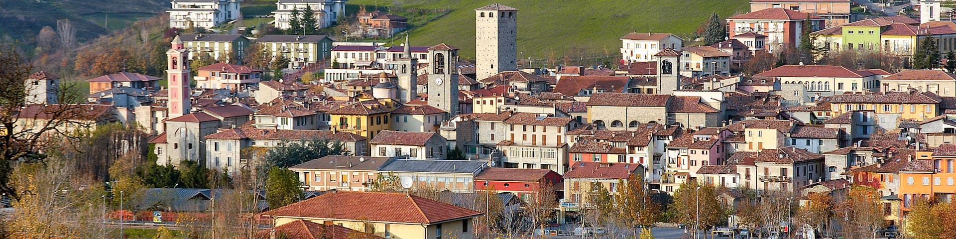 A town nestled in a valley with a prominent church tower, surrounded by rolling hills and green fields.