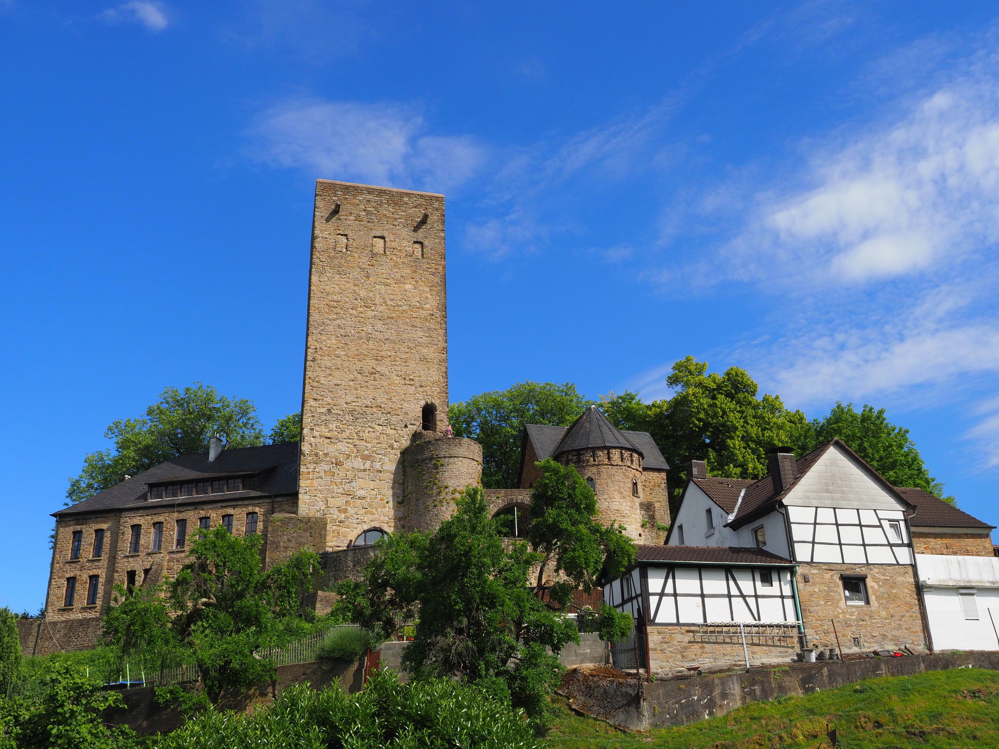 A historic stone tower and buildings with a clear blue sky.