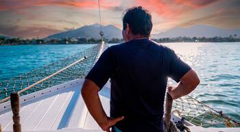 Basilian man watching the sunset on top of a schooner in the city of ubatuba praia itagua in brazil