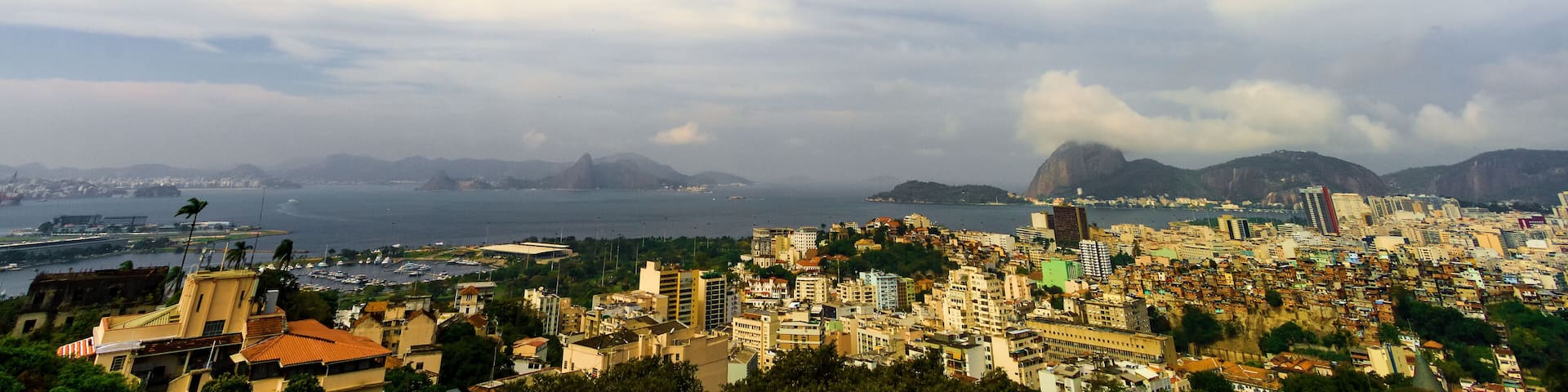 A cityscape with a view of the ocean and mountains in the background.
