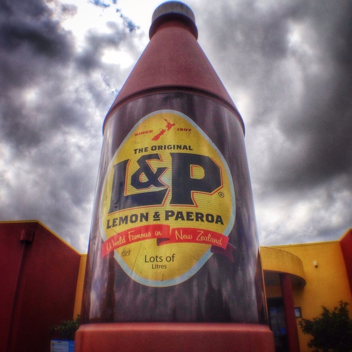 A large, conical structure with a yellow and red label that reads "Lemon & Paeroa" and "The Original I&P."