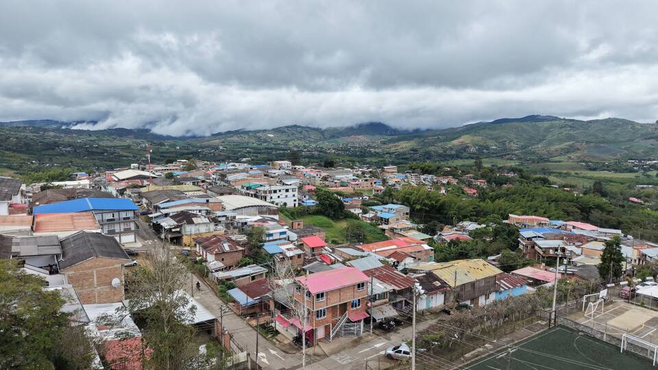 A town with colorful buildings and a mountainous backdrop.