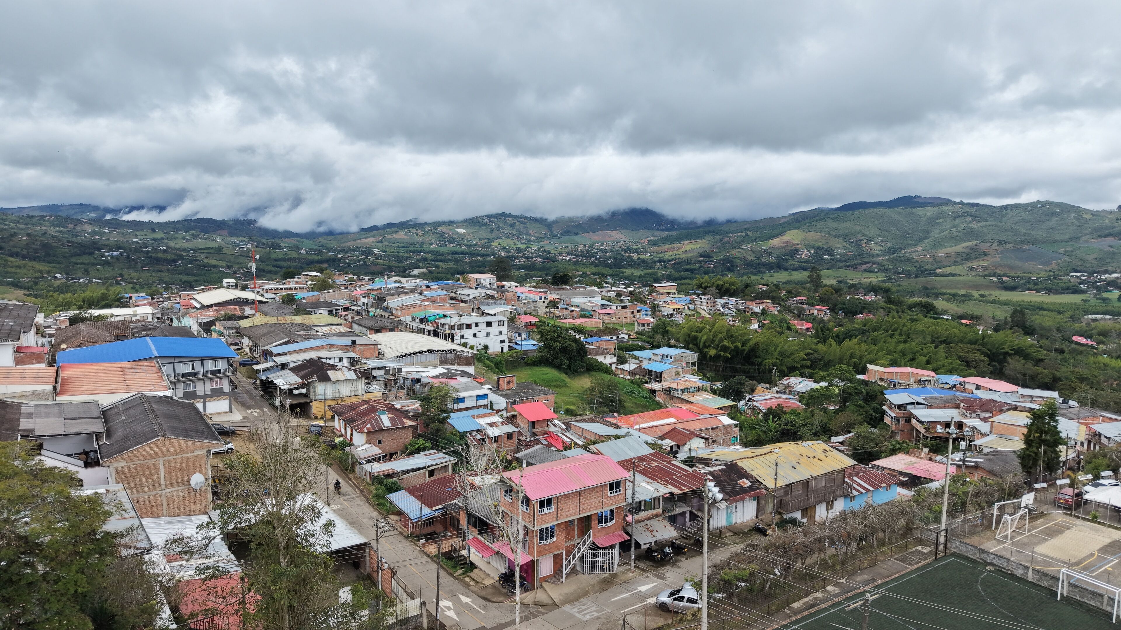 A town with colorful buildings and a mountainous backdrop.