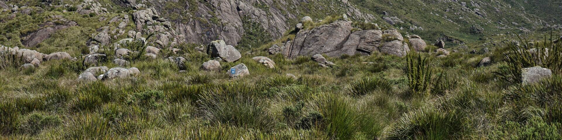 A rugged mountain landscape with rocky outcrops and sparse vegetation.