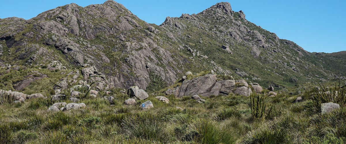 A rugged mountain landscape with rocky outcrops and sparse vegetation.