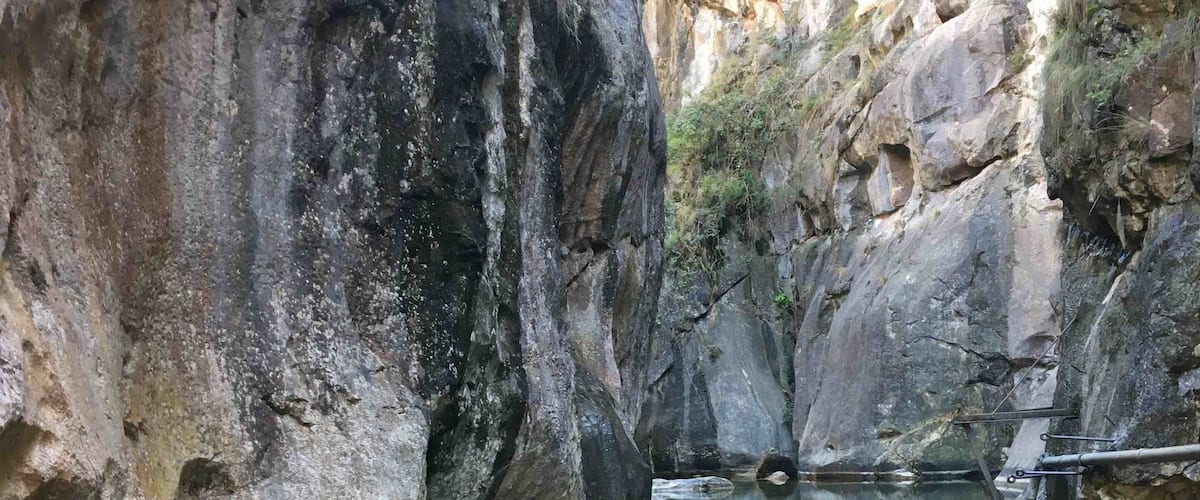 A clear pool surrounded by rocky cliffs.