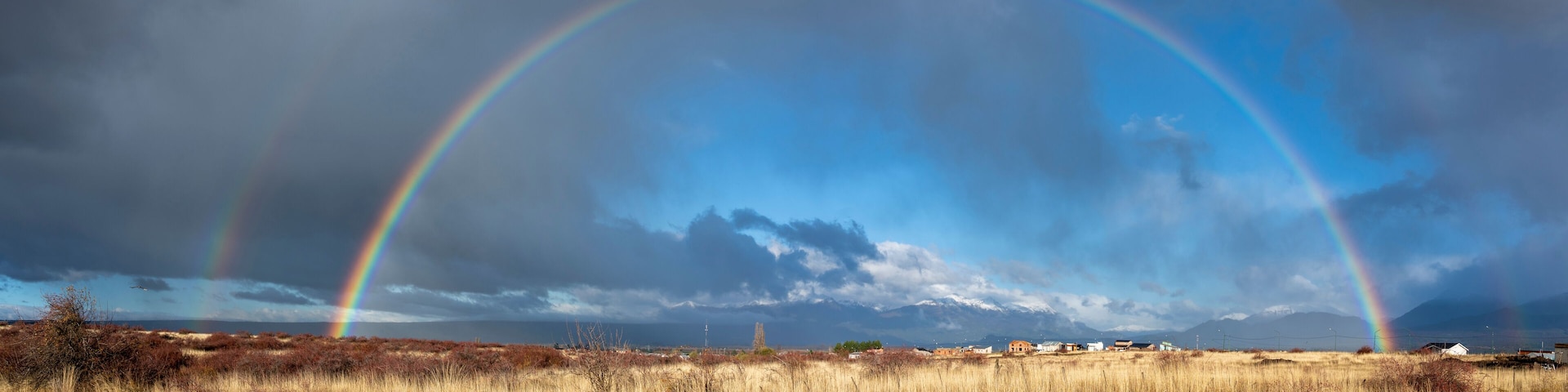 Panoramic view of a double rainbow over Trevelin town in Patagonia