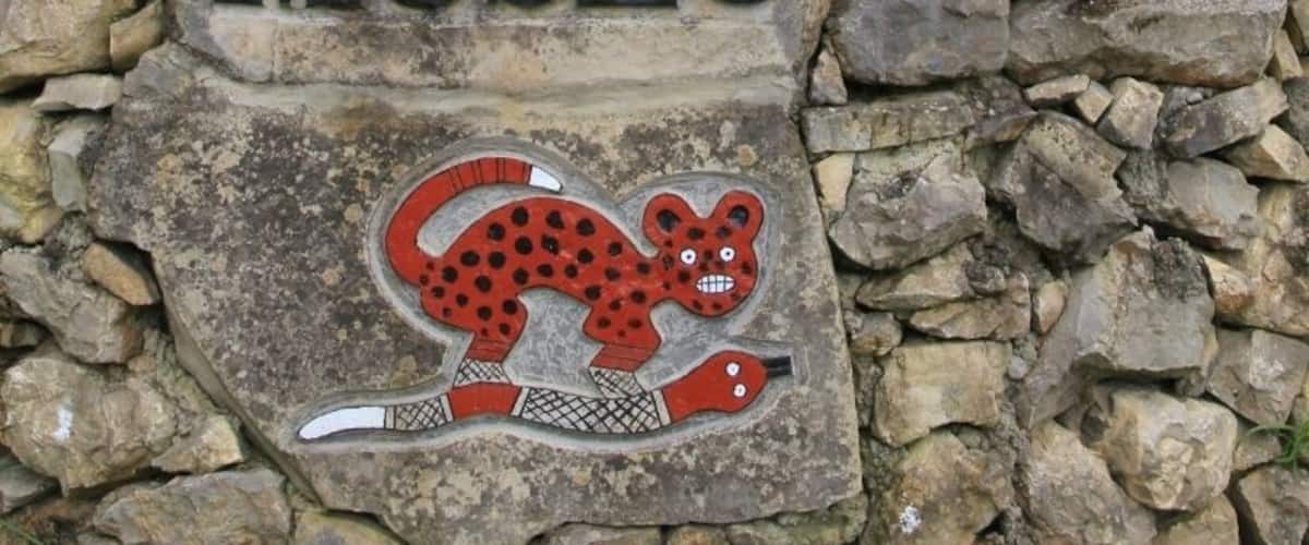 A stone sign with the word "MUSEO" and a decorative animal carving.