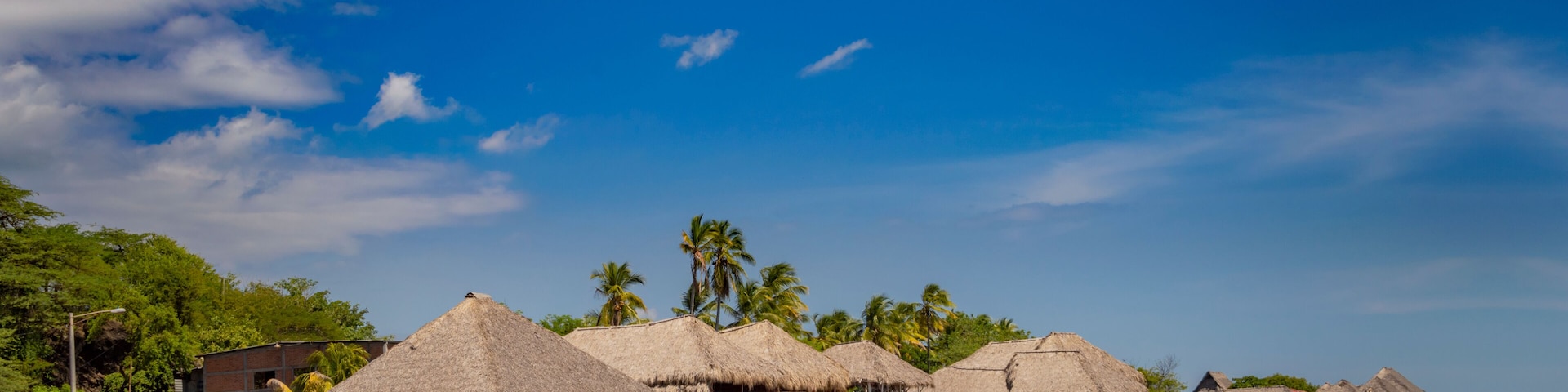 Thatched roof restaurants near the beach, thatched roof restaurant near wooden boats with blue sky, nicaragua restaurants near the beach