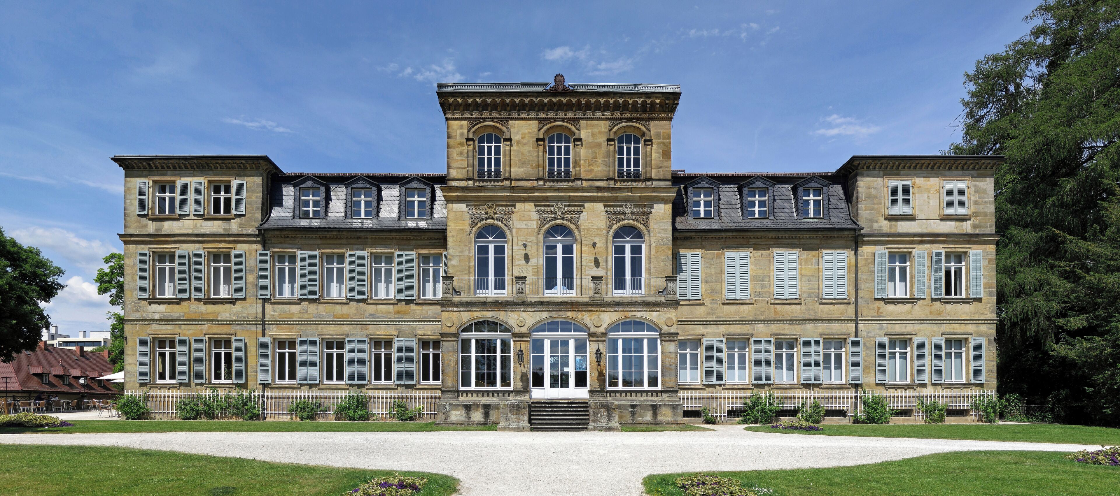 A large, historic building with multiple windows and a central entrance.