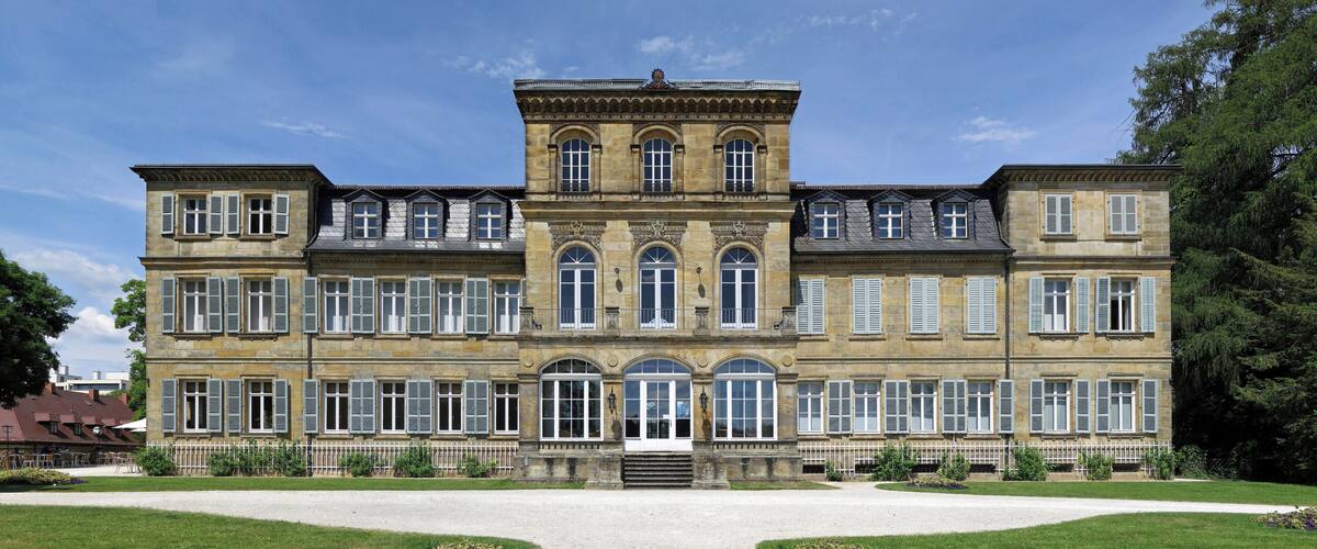 A large, historic building with multiple windows and a central entrance.