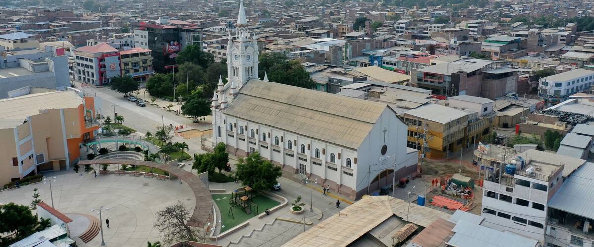 A cityscape with a prominent church, a large open plaza, and dense urban buildings.