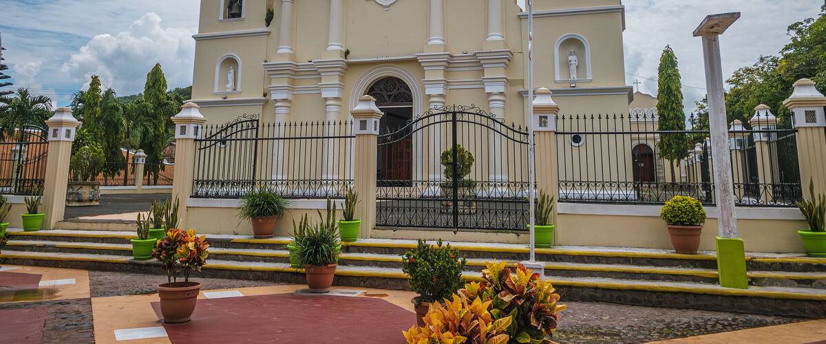 A historic church with a clock tower and a bell.