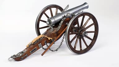Um canhão histórico com rodas de madeira e uma correia de couro.