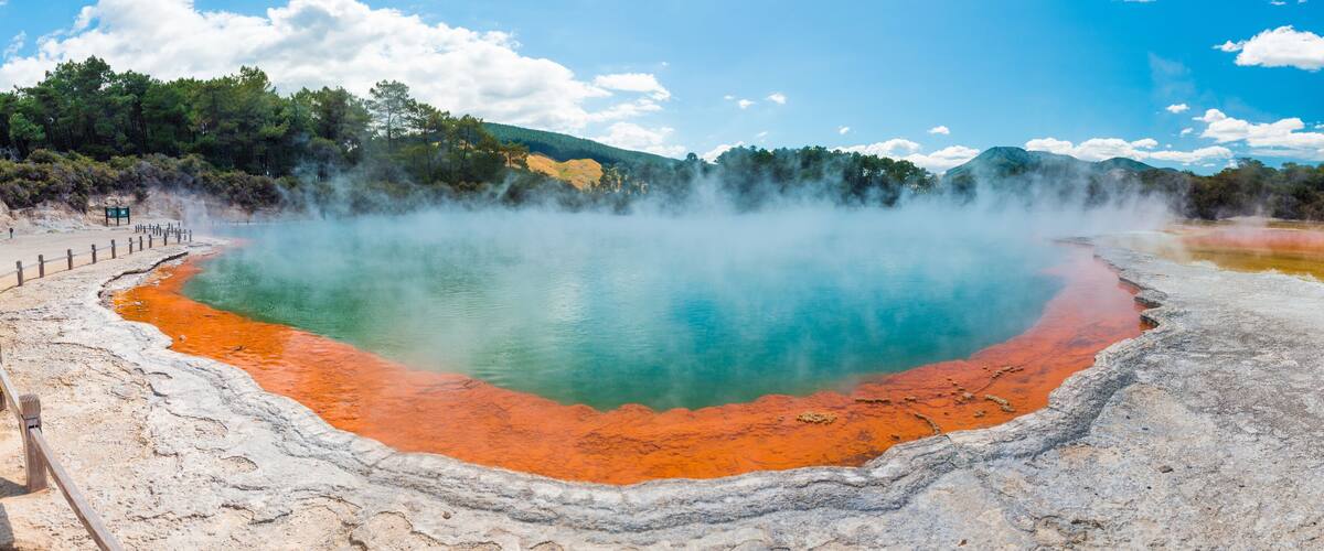 A geothermal hot spring with a wooden walkway.