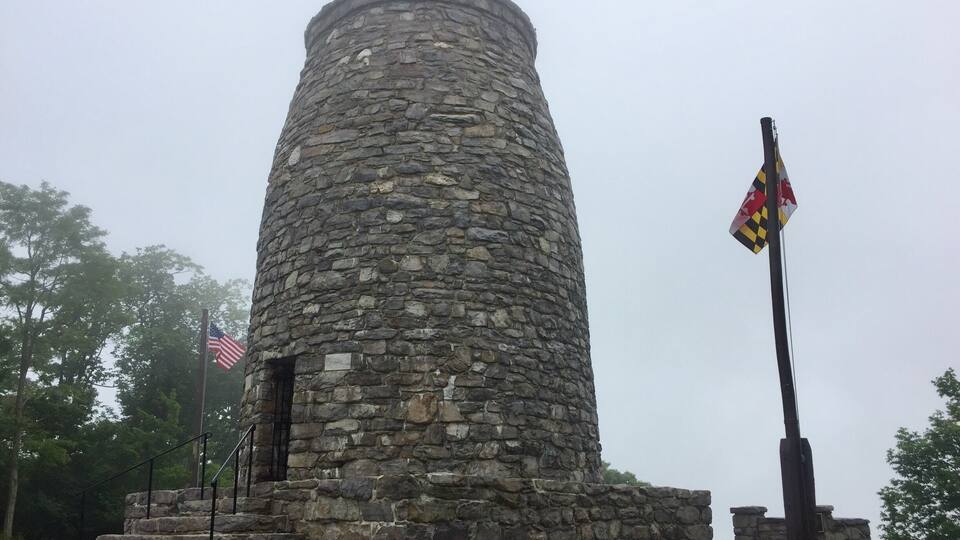 A stone tower with a flagpole and an American flag.
