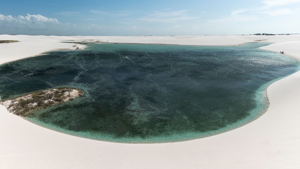 Beautiful view to blue rainwater lagoon on white sand dunes