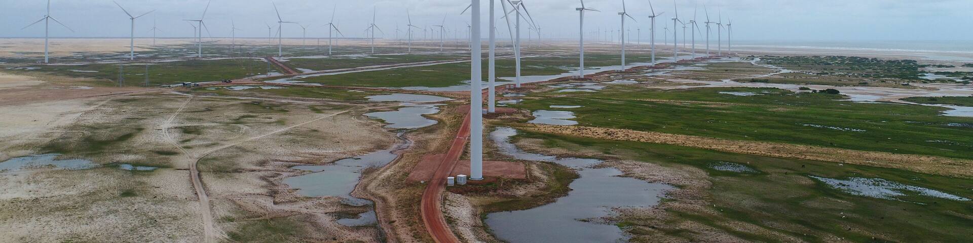Torres eólicas entre dunas e lagoas dos Pequenos Lençóis Maranhenses em Paulino Neves, Maranhão, Brasil, representando energia limpa e paisagem natural
