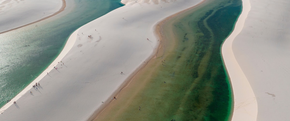 A vast desert landscape with white sand dunes and turquoise waters.