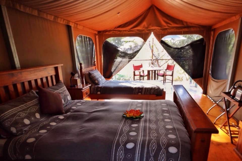 Un alloggio in tenda con un letto, una panca e un tavolo.