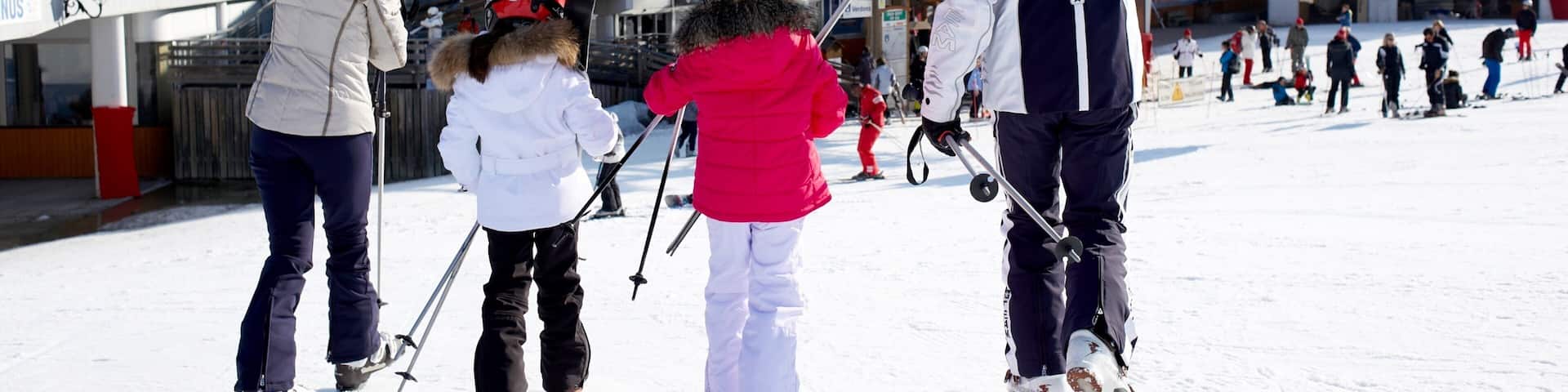 A snowy ski resort with people skiing and walking.